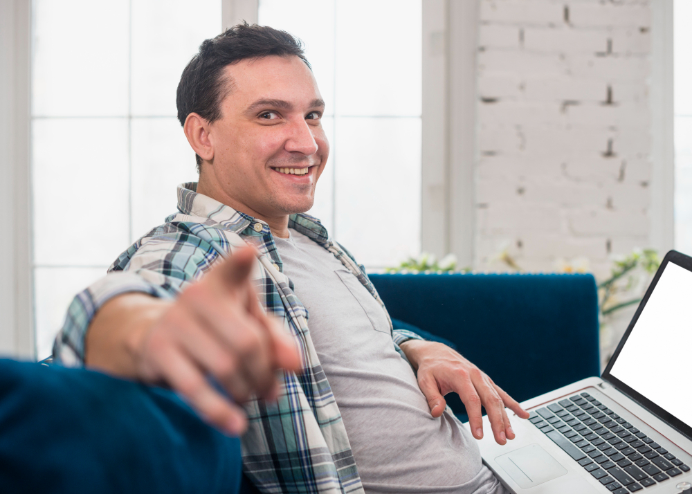Hombre de 40 años sentado en la sala de su casa aprendiendo ingles online